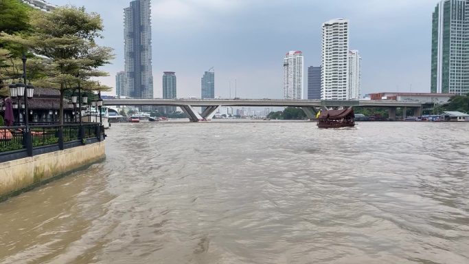Riverside walk beside the Chao Phraya River and Bangkok skyline, Thailand